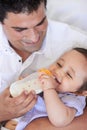 Adoring gaze of a loving father. a a father cradling his baby at feeding time. Royalty Free Stock Photo