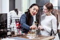 Brunette beautiful asian woman in a navy polo neck and her friend looking at adornments