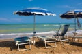 Adriatic Sea coast view. Seashore of Italy, summer umbrellas on sandy beach with clouds on horizon.