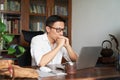 Adult Asian businessman working from home serious and thinking