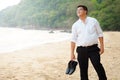 Adult Asian Fat man in white shirt and Carry shoes feeling despondent from hard work be finding relaxing and meditation by walkin