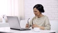 Adult asian female wearing glasses, typing on laptop, sending email to daughter Royalty Free Stock Photo