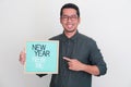 Adult Asian man holding wooden frame with New Year New Me text Royalty Free Stock Photo