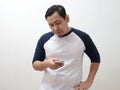 Adult Asian man reading texting chatting on his phone, bad news, sad crying expression Royalty Free Stock Photo