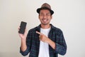 Adult Asian man smiling confident while showing blank mobile phone screen