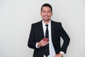Adult Asian man wearing black suit and tie smiling while using mobile phone Royalty Free Stock Photo