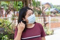 Adult Asian woman wearing medical face mask. Pretty middle female showing how to wear surgical medical mask step by step
