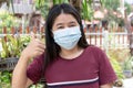 Adult Asian woman wearing medical face mask. Pretty middle female showing how to wear surgical medical mask step by step