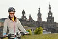 Adult attractive female cyclist posing against the background of