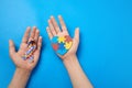 Adult and autistic boy hands holding puzzle heart shape and ribbon. Autism spectrum disorder family support concept