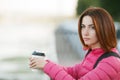 Adult beautiful redhead woman with bob haircut thinking drinking morning coffee in autumn city river pier Royalty Free Stock Photo