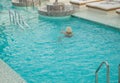 Adult blonde woman enjoys swimming in a luxurious pool on a cruise ship