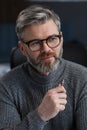 Adult businessman in office. Close-up business portrait of handsome gray hair man wearing eyeglasses sitting at Royalty Free Stock Photo