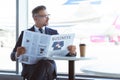 adult businessman reading newspaper and looking at window Royalty Free Stock Photo