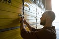 Adult calm man using the lock from the storage room