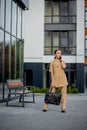 Adult Caucasian Confident Young Business Woman is Talking on Phone Outside near Modern Office Building Royalty Free Stock Photo