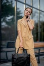 Adult Caucasian Confident Young Business Woman is Talking on Phone Outside near Modern Office Building Royalty Free Stock Photo