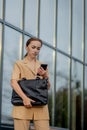 Adult Caucasian Confident Young Business Woman is Talking on Phone Outside near Modern Office Building Royalty Free Stock Photo