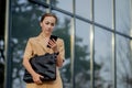 Adult Caucasian Confident Young Business Woman is Talking on Phone Outside near Modern Office Building Royalty Free Stock Photo