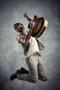 Adult caucasian guitarist portrait playing electric guitar and jumping on grunge background. Music singer modern concept Royalty Free Stock Photo