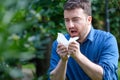 Adult caucasian man sneezes because of an allergy. Royalty Free Stock Photo