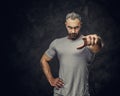 Adult caucasian muscular bodybuilder showing a gesture with his hand and looking angry on camera, portrait look Royalty Free Stock Photo