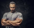 Adult caucasian muscular bodybuilder showing his muscles with arms crossed and looking on camera, portrait look Royalty Free Stock Photo