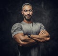 Adult caucasian muscular bodybuilder showing his muscles with arms crossed and looking on camera, portrait look Royalty Free Stock Photo