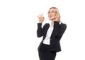 Adult caucasian smiling woman in eyeglasses and formal wear talking on the cellphone and gesturing with her hand Royalty Free Stock Photo