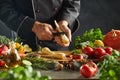 Adult chef peeling carrot above cutting board