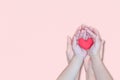 adult and child hand holding red heart on pink background Royalty Free Stock Photo