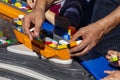 Adult and child hands building lego boats