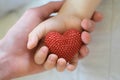 Adult and child hands holding red heart Royalty Free Stock Photo