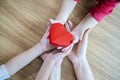 Adult and child hands holding red heart on aqua background, heart health, donation, CSR concept Royalty Free Stock Photo