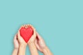 Adult and child hands holding red heart over white background. Love, healthcare, family, insurance, donation concept Royalty Free Stock Photo
