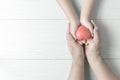 Adult and child hands holding red heart on vintage tone Royalty Free Stock Photo