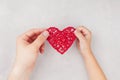 Adult and child holding red heart in hands from above. Family relationships, health care, pediatric cardiology concept. Royalty Free Stock Photo