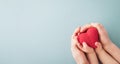 Adult and child holding red heart in hands top view. Happy family relationships, health care, pediatric cardiology concept Royalty Free Stock Photo