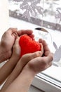 Adult and child holding red heart in hands top view. Happy family relationships Royalty Free Stock Photo