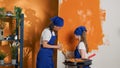 Adult and child painting interior walls with orange paint color Royalty Free Stock Photo