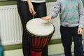 An adult and a child are playing a musical instrument. African djembe Meinl. Shallow depth of field