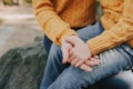 Adult and child in the same yellow knitted sweaters and blue jeans hold hands tightly, faceless trend, family care