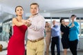 Adult couple enjoying slow foxtrot in dance studio