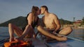 Adult couple kissing on top of their paddlesurf boards on the beach