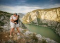 Adult couple kissing and travel raised hands on cliff Royalty Free Stock Photo