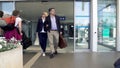 Adult couple leaving airport, people arriving on vacation, family holidays