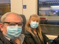 Adult couple taking a selfie on the train wearing a surgical mask during the covid pandemic Royalty Free Stock Photo