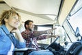 Adult couple traveling with home vehicle camper cabin. Man pointing destination at woman. Happy couple living vanlife adventure