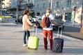 An adult couple travels with suitcases along the street. Love travel and transportation. Travel concept and planning happy holiday