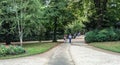 Adult couple with umbrella stroll through the Luxembourg Garden, Paris, France, on a summer day